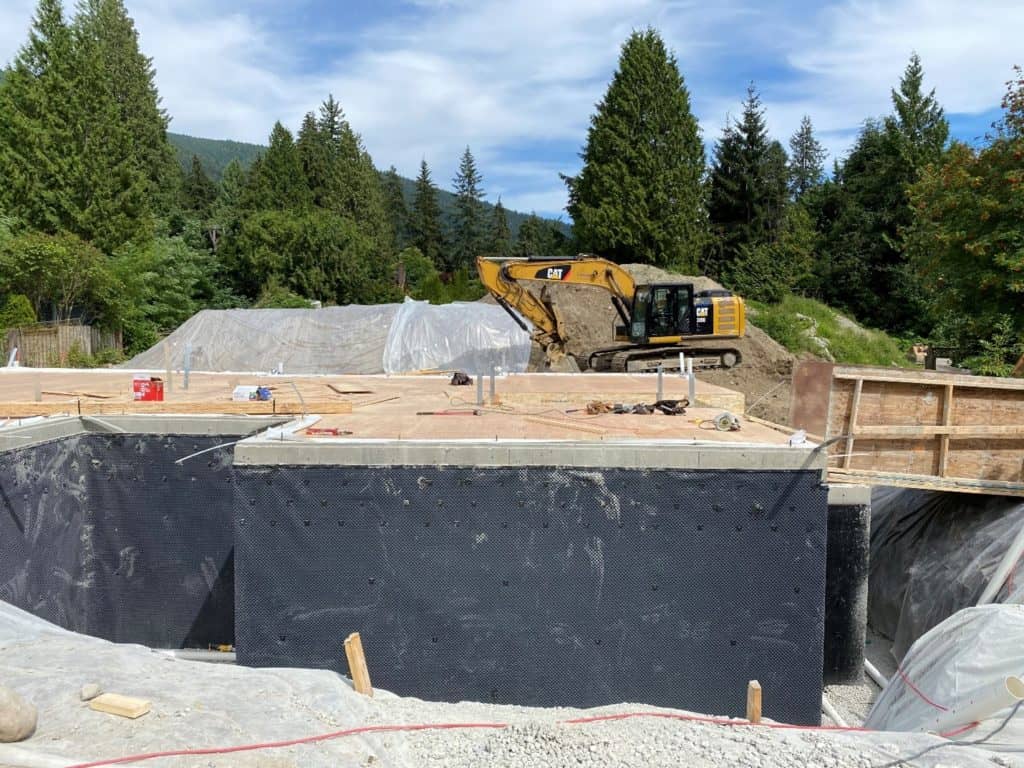 CRANE DELIVERING LUMBER INTO FOUNDATION